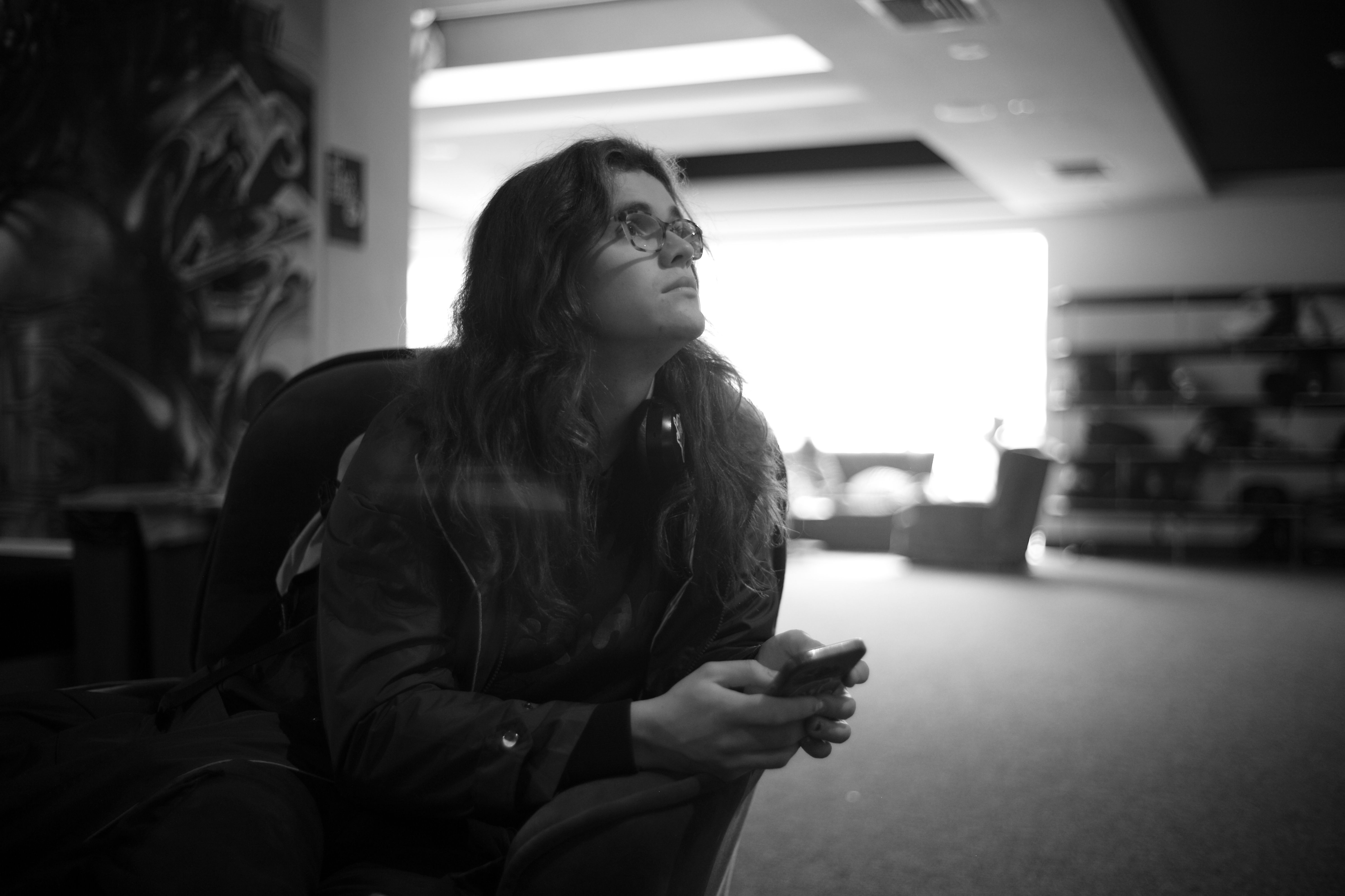 Black and white photo of someone sitting and staring into the distance